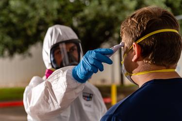 Before disinfecting a building during the coronavirus pandemic, workers for Code 4 Event Management have their oxygen levels and temperatures checked to ensure they are not exhibiting symptoms of the virus.