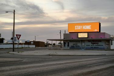 The intersection of Kermit Highway and Andrews Highway in Odessa is empty as an advertisement urges people to stay home during the coronavirus pandemic.